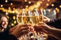 Happy friends having fun and toasting sparkling wine glasses close-up against golden bokeh lights background Royalty Free Stock Photo