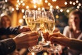 Happy friends having fun and toasting sparkling wine glasses close-up against golden bokeh lights background