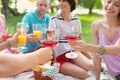 Happy friends having picnic in park on sunny day, Royalty Free Stock Photo