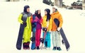 Happy friends in helmets with snowboards talking Royalty Free Stock Photo