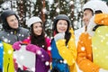 Happy friends in helmets with snowboards talking Royalty Free Stock Photo