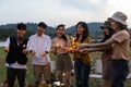 Happy friends holding fire sparkles. Group of young Travel join in fun at camping party in nature. Vacationers enjoy camping at Royalty Free Stock Photo