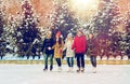 Happy friends ice skating on rink outdoors Royalty Free Stock Photo