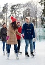 Happy friends ice skating on rink outdoors Royalty Free Stock Photo