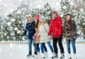 Happy friends ice skating on rink outdoors Royalty Free Stock Photo