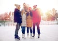 Happy friends ice skating on rink outdoors Royalty Free Stock Photo