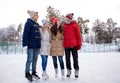 Happy friends ice skating on rink outdoors Royalty Free Stock Photo