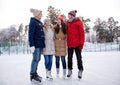 Happy friends ice skating on rink outdoors Royalty Free Stock Photo