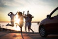 Happy friends jumping near car outdoors at sunset. Summer trip Royalty Free Stock Photo