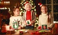 Happy friends kids draw decorations and write letter to Santa near Christmas tree