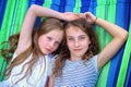 Friends are laughing on a hammock on a hot sunny day