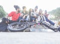 Happy friends listening music in city park - Breaker,skaters and freestyle bikers having fun together - Concept of diverse culture Royalty Free Stock Photo