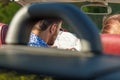 Happy friends with map driving in cabriolet car at country and pointing finger to something ahead Royalty Free Stock Photo