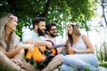 Happy friends in the park having picnic on a sunny day. Royalty Free Stock Photo