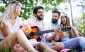 Happy friends in the park having picnic on a sunny day. Royalty Free Stock Photo