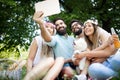 Happy friends in the park having picnic on a sunny day. Royalty Free Stock Photo