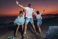 Friends partying on the beach with drinks. Happy young people having fun at beach party, celebrating together Royalty Free Stock Photo