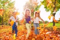 Happy friends play with colorful leaves in forest