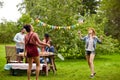 Happy friends playing badminton at summer garden