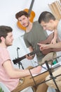 Happy friends playing guitar and listening to music at home Royalty Free Stock Photo