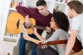 happy friends playing guitar and listening to music at home Royalty Free Stock Photo