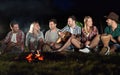 Happy friends playing music and enjoying bonfire Royalty Free Stock Photo