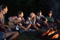 Happy friends playing music and enjoying bonfire Royalty Free Stock Photo