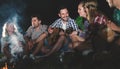 Happy friends playing music and enjoying bonfire Royalty Free Stock Photo