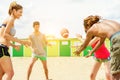 Happy friends playing rugby on sand beach with back sun light - Young people having fun with sport summer games - Holidays and Royalty Free Stock Photo