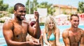 Happy friends playing in swimming pool party - Young diverse culture people having fun on summer vacation - Focus on black man Royalty Free Stock Photo