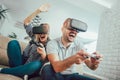 Happy friends playing video games with virtual reality glasses Royalty Free Stock Photo