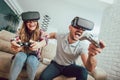 Happy friends playing video games with virtual reality glasses Royalty Free Stock Photo