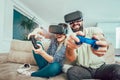 Happy friends playing video games with virtual reality glasses Royalty Free Stock Photo