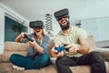 Happy friends playing video games with virtual reality glasses