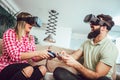 Happy friends playing video games with virtual reality glasses Royalty Free Stock Photo