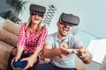 Happy friends playing video games with virtual reality glasses Royalty Free Stock Photo