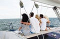 Happy friends sailing and sitting on yacht deck