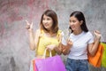 Happy friends with shopping bags holding money. Two excited shop Royalty Free Stock Photo