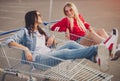 Happy friends in shopping trolleys talking with each other Royalty Free Stock Photo