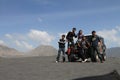 Happy friends sitting on a jeep at desert