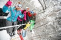 Happy friends skiers on ski lift ride up on ski slope at snowy d