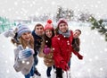 Happy friends with smartphone on ice skating rink Royalty Free Stock Photo