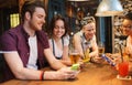 Happy friends with smartphones and drinks at bar Royalty Free Stock Photo