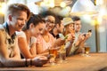 Happy friends with smartphones and drinks at bar Royalty Free Stock Photo