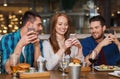 Happy friends with smartphones at restaurant Royalty Free Stock Photo