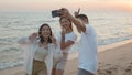 Happy friends smiling and posing taking selfie from smartphone and having fun together on beach Royalty Free Stock Photo