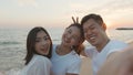 Happy friends smiling and posing taking selfie from smartphone and having fun together on beach Royalty Free Stock Photo