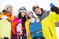 Happy friends with snowboards and smartphone Royalty Free Stock Photo