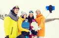 Happy friends with snowboards and smartphone