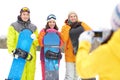 Happy friends with snowboards and smartphone